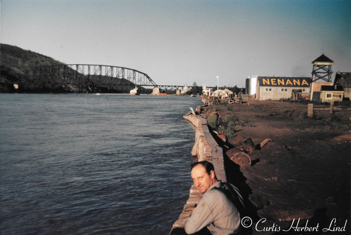 The town of Nenana was regularly flooded in late summer (August usually) with the rising waters of the Tanana River. Here at the right is the clock tower that sets out on the ice in the spring to trip the time for the Nenana Ice Classic. The warm tone and shadows indicate this is about 11:30 p.m. as the sun dips toward the horizon. Tanana River Bridge Bridge 413.7 in the background 