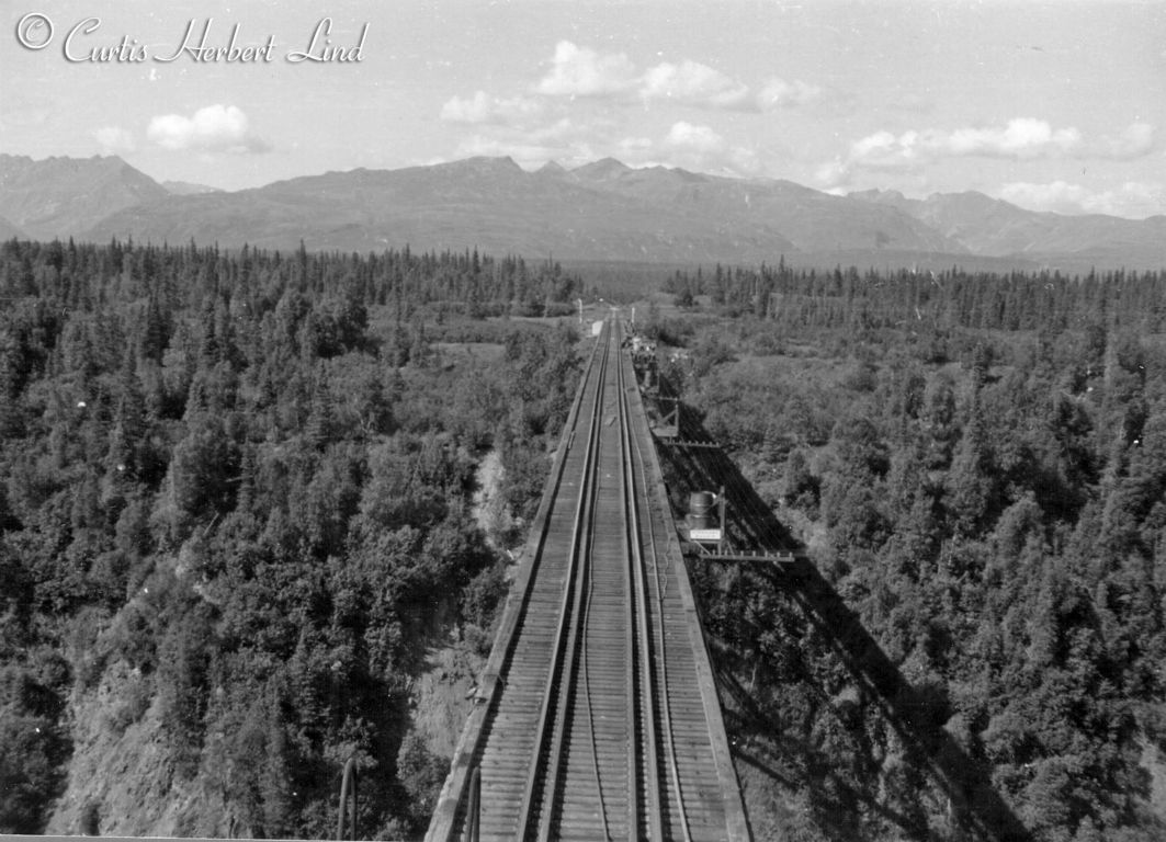 Looking South over the Hurricane Gulch Bridge mid morning with the shadows on the down stream side of the bridge. Notice the water barrels on the platforms that also support the telecom cross bars and insulators.