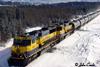 A northbound tank train kicks up snow at the Healy overpass